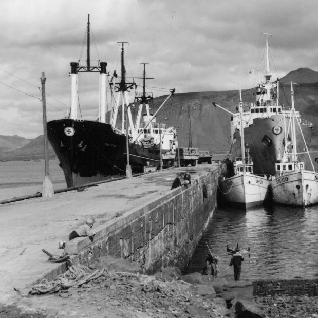 Lífið við höfnina og mikið um að vera. Tvö skip frá Eimskipafélaginu og útskipun í gangi, þrír heimabátar við bryggju og börn að leik.