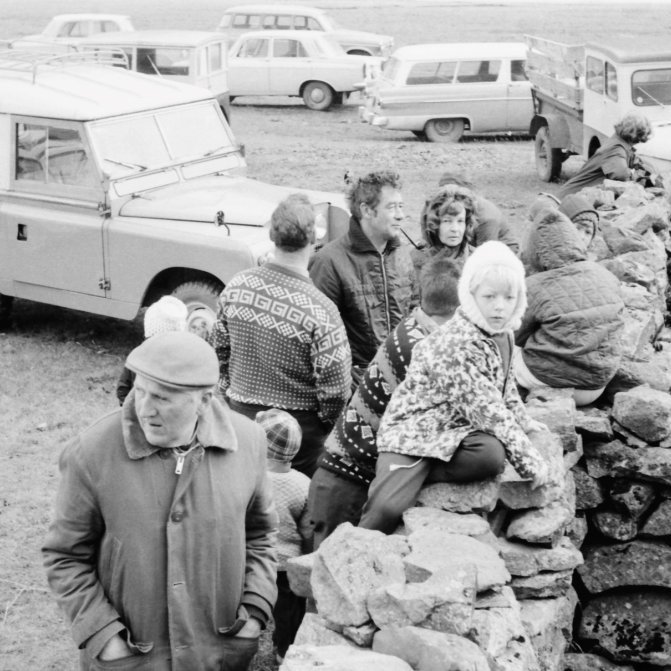Skemmtileg mynd úr Grundarrétt. Lengst til vinstri er Sigurjón Halldórsson og uppi á réttarveggnum er sonardóttir hans Björg Bára Halldórsdóttir, getur verið að maðurinn og drengurinn sem snúa bakinu í myndavélina séu þeir feðgar Halldór Sigurjónsson og Halldór Kristinn Halldórsson? Á miðri myndinni eru hjónin frá Gröf Þorsteinn Bárðarson og Elna Bárðarson. Glöggir gæru síðan þekkt manninn sem situr í bílnum lengst til hægri og aðrir á myndinni gæru þekkst á fötunum, einnig væri hægt að þekkja til bílanna á myndinni og hverjir eigendur þeirra eru.