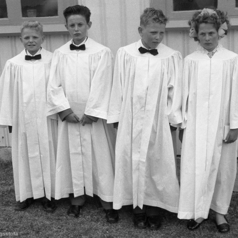Fermingarmynd tekin af fermingarsystkinum fyrir utan Setbergskirkju árið 1958. Þau voru ekki mörg fermingarbörnin þetta árið börn sem fædd voru lýðveldisárið 1944. Þann 17 júní 1944 var Íslenska lýðveldið stofnað og aðeins eitt af þessum börnum fæddist undir dönsku krúnunni en hin þrjú þegar Ísland var orðið sjálfstætt, hvort það var það sem Guðni Hallgríms er að hvísla að Gunnu Nóa fermingarsystur sinni eða eitthvað annað þá er hún allavega alvarleg á svipinn en hann sposkur á svipinn eins og oft enda prakkari mikill. Fermingarsystkinin talið frá vinstri eru Kristján Elberg Guðmundsson Grafarnesi, Nesvegi 9, Lúðvík Jakobsson Grundargötu 37, Guðni Eggert Hallgrímsson Grundargötu 25 gömlu símstöðinni og Jónína Guðrún Nóadóttir Vindási.