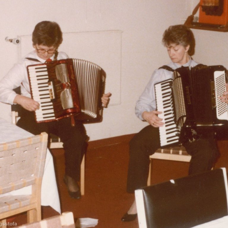 Þær Lauga og Stína stigu oft á stokk á skemmtunum og skemmtu með harmonikkuleik. Hér eru þær að skemmta á kvenfélagsfundi í kirkjukjallaranum. Guðlaug Guðmundsdóttir og Kristín Friðfinnsdóttir.