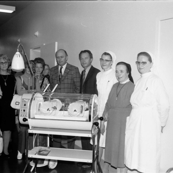 Kvenfélagskonur í Kvenfélaginu Gleym mér ei komu oft að málum þegar tækjabúnað eða annað vantaði til samfélagsins. Hér eru þær að færa St. Fransisku sjúkrahúsinu í Stykkishólmi hitakassa fyrir nýbura og ungabörn. Kvenfélagskonur frá Grundarfirði, talið frá vinstri: Gróa H. Guðjónsdóttir, Hulda Vilmundardóttir, Ragnheiður Benidiktsdóttir, Guðrún Árnadóttir, Bára Hallgrímsdóttir, Jóhanna Sigurrós Árnadóttir, Rósa Geirmundsdóttir og Valgerður Skarphéðinsdóttir. Getur verið að systirin sem er lengst til vinstri sé systir Lena? Okkur vantar nöfn Sankti Fransisku systranna og karlmannanna sem eru á myndinni.