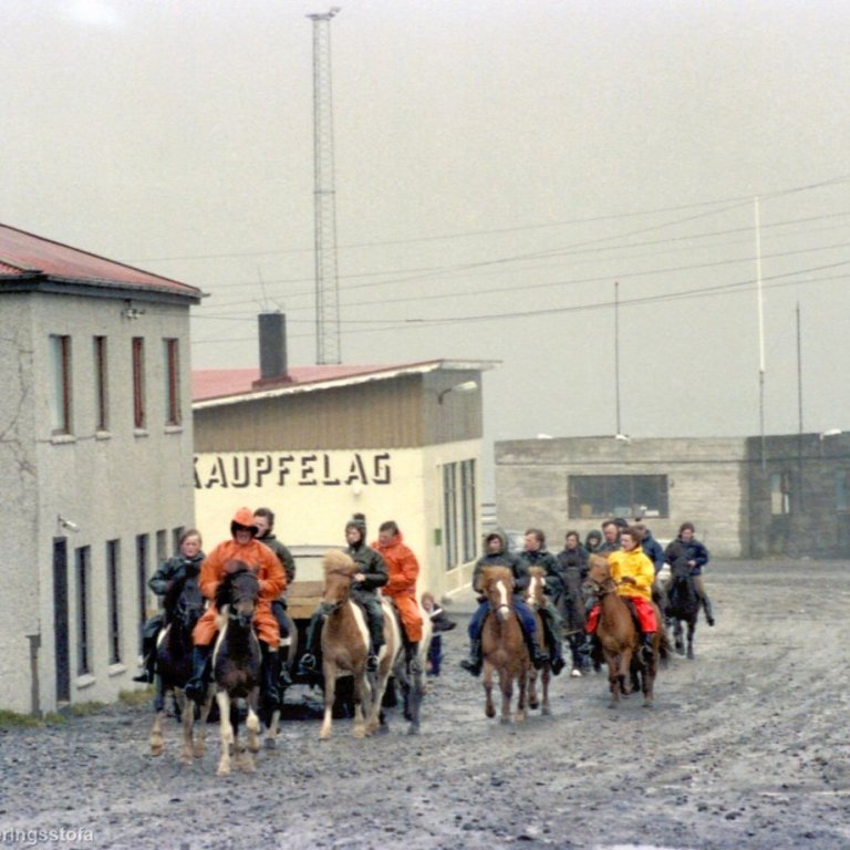Hestamenn á ferð upp Borgarbrautina í suddaveðri og ekki er gatan glæsileg. Það er gaman að spreyta sig á nöfnum hestamannanna og jafnvel nöfnum hestanna. Hafnarhúsið er þarna frekar nýtt og landað að ofanverðu, Kaupfélagið í rekstri og ef ekkert skyggði á þá væri jafnvel Kaupfélagspollurinn sýnilegur. Hver man eftir þessum rafmagns- eða símalínum sem liggja frá Borgarbraut 2?