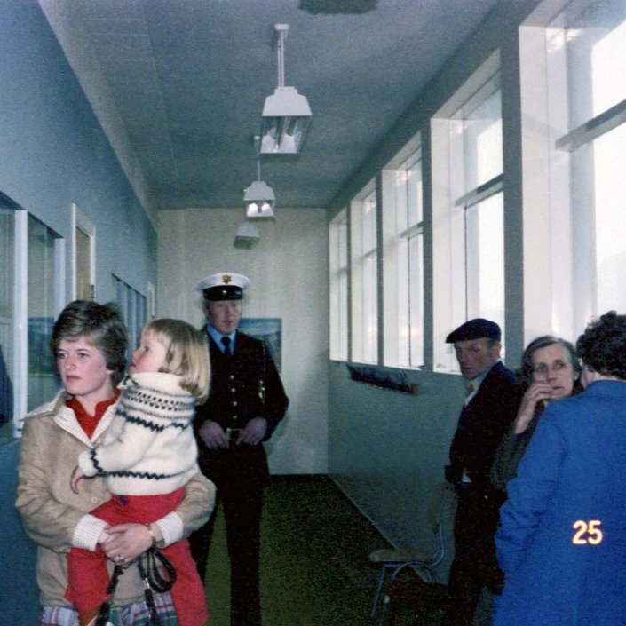 Kosningar árið 1978. Edda Hringsdóttir er hér með dóttur sína Sigrúnu Hafsteinsdóttur í fanginu og búin að kjósa. Lögreglumaðurinn er Ívar Árnason eða Vilhjálmur Pétursson (myndin er aðeins villandi). Síðan eru á myndinni hjónin frá Eyri þau Guðmundur Guðmundsson og María Elíasdóttir. Okkur vantar nafn konunnar sem snýr baki við ljósmyndaranum.