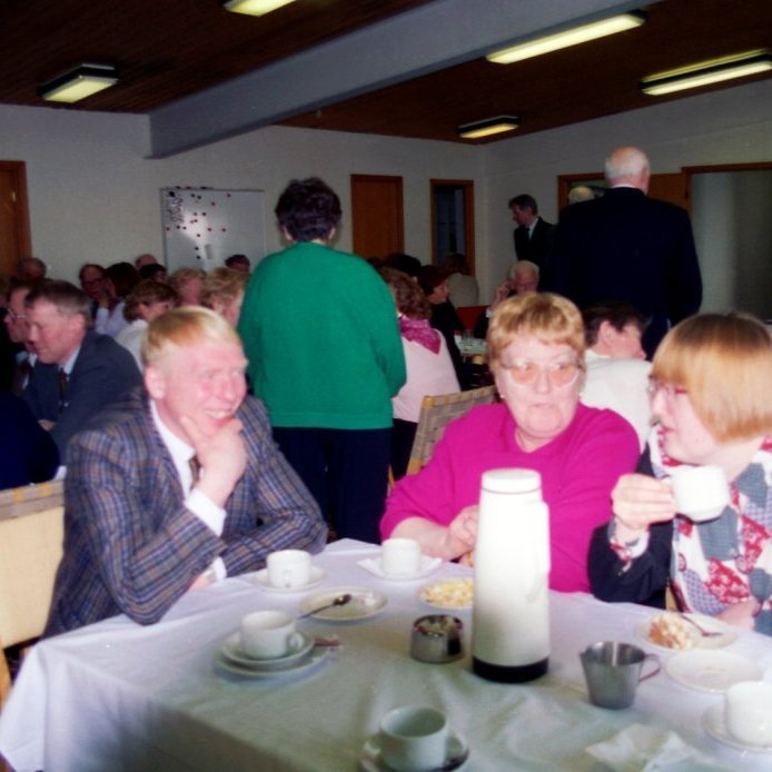 Samkoma í Fiskverkun Soffaníasar Cecilssonar. Á fremsta borði sitja þau saman fjölskyldan frá Mýrum, Ólafur Jónsson og kona hans Anna Júlía Skúladóttir, en á milli þeirra er móðir Ólafs, hún Hjördís Inga Einarsdóttir.
