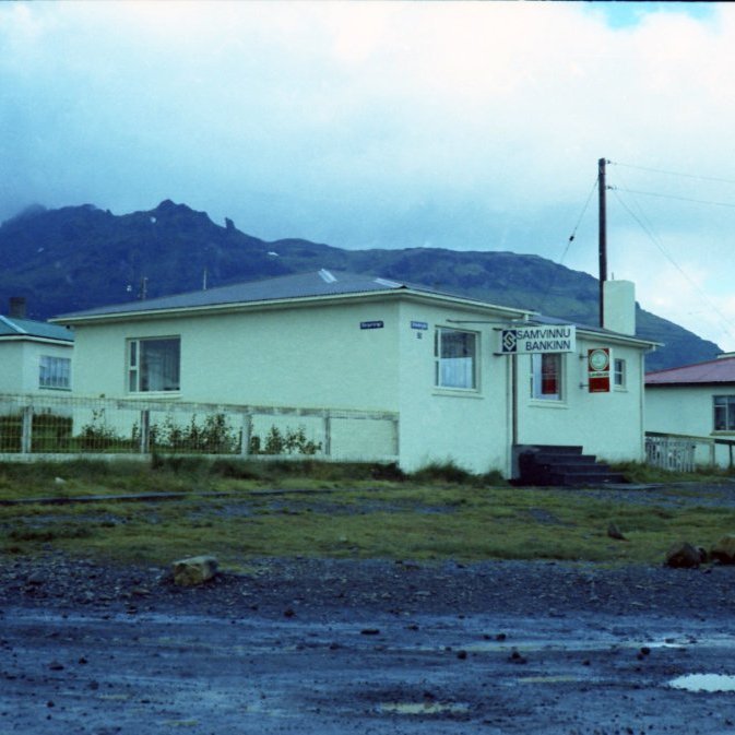 Á þessari mynd er Samvinnubankinn og Samvinnutryggingar komnar í húsnæði á Grundargötu 25 sem áður hýsti Símstöðina og fjölskyldu stöðvarstjórans Guðríðar Sigurðardóttur. Á þessum tíma voru göturnar í Grundarfirði og víðar ekki upp á marga fiska og víða drullupollar, eins voru girðingar við mörg hús og misjafnlega auðvelt að ganga eftir þeim sem var mjög vinsælt hjá yngri kynslóðinni við litla hrifningu húseigenda. Til hægri er Grundargata 27 á þessum tíma hús Báru og Magnúsar frá Hrísey, næst er Grundargata 29 hús Mýrarhúsa fjölskyldunnar Báru Péturs og Ella Guðjóns en upp bjuggu foreldrar Báru þau Pétur Konn og Dísa. Borgarbraut 6,hús Hinna og Röggu er lengst til vinstri á myndinni, þau bjuggu á hæðinni en Þórdís móðir Röggu bjó á efri hæðinni.  Þar næst er Hamrahlíð 2 Hús Ólafar frá Hömrum og má sjá gróðurkassa undir húsveggnum, á þessum árum byrja íbúar að planta trjám og rækta garðana sína.