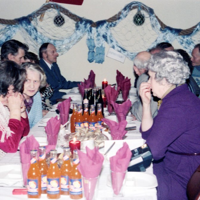 Þorrablót í samkomuhúsinu, fallega skreytt með sjávar þema og kræsingar á borðum. Á myndinni má þekkja Þorkötlu Bjarnadóttur, Elías Finnbogason, Petreu Pálsdóttur, Runólf Þorkelsson, Óskar Sæmundsson og Christel Kjartansson, það má spá í höfuð hverra sést í á myndinni. Eru þetta Guðmundur Runólfsson, Ingibjörg Kristjánsdóttir, Pétur Konráðsson og Kristján Kristjánsson?