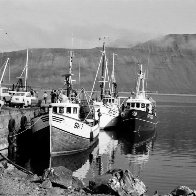 Bátar, bílar og fólk. Fremst á myndinni er Hafsúlan SH-7 í eigu Halldórs Sigurðssonar (Dóra á Hafsúlunni), Þar fyrir aftan er Sigurfari SH-105 Hjálmars Gunnarssonar.  Utan á Sigurfara liggur Hamraborg SH- 222 smíðuð í Vélsmiðjunni Herði h/f fyrir Ásgeir Valdimarsson, sem var skipstjóri, og Víði Jóhannsson vélstjóra í Grundarfirði. Það væri gaman að fá upplýsingar um bílana á myndinni og eitthvað af fólkinu þekkist jafnvel?