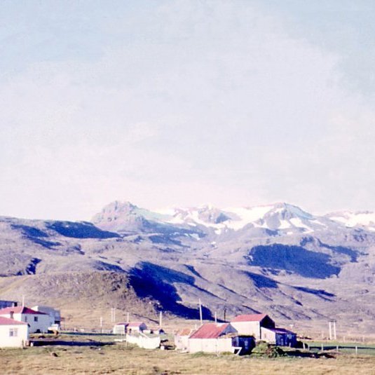 Þessi skemmtilega mynd er tekin á milli áranna 1960 og 1970, glöggir geta áttað sig á hvaða ár myndin er tekin. Þarna er ysta húsið Grundargata 47 sem þau Garðar og Ólöf byggðu, næsta hús fyrir innan er tvíbýlishús bræðranna frá Hellnafelli Grundargata 45. Á efri hæðinni bjuggu þau Sigurberg Árnason og Jóhanna Sigurðardóttir ásamt börnum sínum og á neðri hæðinni Ívar Árnason og Jóhanna Gústafsdóttir (Hanna) ásamt sonum sínum, þar næst er húsið að Grundargötu 43 sem lengi var prestbústaðurinn eftir að presthjónin ásamt syni sínum Sigurbirni, þau séra Magnús Guðmundsson og frú Áslaug Sigurbjörnsdóttir og fluttu frá Setbergi. Einnig bjuggu í nokkur ár á þessum tíma hjónin Elís (Elli frá Vatnabúðum) og Ragna á Grundargötu 43 ásamt sonum sínum. Lengst til vinstri á myndinni er svo Grundargata 41 (Fagurhóll). Fremst á myndinni er Mýrarhús (Grundargata 42) en í dag Sæból 13. Pétur Konráðsson (Pétur Konn) og Jódís (Dísa) Björnsdóttir og börn þeirra fluttu í þetta hús þegar þau fluttu frá Vík (í útsveitinni) og í þorpið. Lengi bjuggu í þessu húsi þau Gunnar íslendingur og Guðlaug Hansdóttir (Gulla) ásamt fjölskyldu. Margir eiga góðar minningar frá tímabili veitingahússins Krákunnar í þessu húsi, Friðfinnur Friðfinnsson og Halla Elimarsdóttir, þau Halla og Finni bjuggu í þessu húsi og ráku Krákuna í nokkur skemmtileg ár. Fyrir ofan Mýrarhús er síðan Sigurhæðir (Grundargata 44) þar bjuggu alla tíð hjónin frá Þórdísarstöðum þau Jeremías Kjartansson og Cecilía Kristjánsdóttir ásamt 11 börnum sínum. Byggingarnar þar fyrir utan eru útihús og í dag er þarna Fjölbrautarskóli Snæfellinga á Jeratúni.