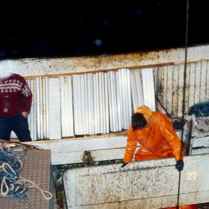Þessi skemmtilega mynd er greinilega tekin á vetrarvertíð árið 1980 hver er skipstjórinn sem fylgist þarna vel með en snjókorn fer fyrir andlitið, hver er sjómaðurinn sem er á lúgunni og hvaða bátur er þetta?