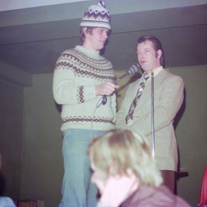 Þessi skemmtilega mynd er tekin á skemmtun í samkomuhúsinu árið 1976. Þarna eru þeir félagar Árni Emilsson (Snolli) og Friðfinnur Friðfinnsson (Finni) rúmlega þrítugir að aldri að skemmta á litla sviðinu í samkomuhúsinu. Það má á þessari mynd sjá hvað Orri sonur Snolla og Steini sonur Finna eru líkir feðrum sínum. Til gamans er einnig hægt að sjá svip af leikurunum Tom Cruise og Humphrey Bogart ef vel er að gáð. Árni lést 17 febrúar árið 2021, 77 ára að aldri lést. Friðfinnur 26.janúar árið 2020, 78 ára að aldri.