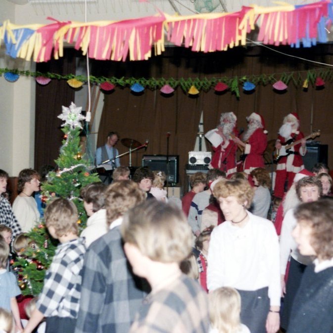 Þessi mynd frá jólaballi kvenfélagsins er sennilega frá árinu 1986 og jólasveinarnir orðnir rafmagnaðir og með hljóðkerfi og hafa Níels Friðfinnsson (Nilla) sér til aðstoðar á rafmagnsorgel. Þarna má þekkja flest andlitin og jafnvel vangasvip þeirra sem eru að ganga í kring um litla jólatréð.