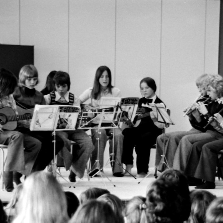 Stofnun tónlistarfélags í Grundarfirði: Stofnfundur tónlistarfélagsins í Grundarfirði var haldinn í safnaðarheimili kirkjunnar, fimmtudaginn 5. desember 1974, klukkan 21:00. Séra Jón Þorsteinsson setti fundinn fyrir hönd undirbúningsnefndar. Það voru 21 manns á fundinum. Á fundinum las sr. Jón drög að lögum um tónlistarfélag í Grundarfirði sem voru mjög lík þeim sem voru í Ólafsvík þar sem sr. Árni Bergur Sigurbjörnsson hafði látið undirbúningsnefndina fá ýmis gögn. Fundurinn samþykkti samhljóða að stofna tónlistarfélag í Grundarfirði. Kosið var í stjórn félagsins og var sr. Jón Þorsteinsson kosinn formaður, Jensína Guðmundsdóttir gjaldkeri og Tryggvi Gunnarsson ritari. Einnig var rætt um að skólagjöld færu eftir styrkjum og til hliðsjónar væru skólagjöld við aðra skóla. Sr. Jón sagðist vera að bíða eftir svari frá menntamálaráðuneytinu og var hann bjartsýnn á að skólinn gæti hafist strax eftir áramót. Fyrstu tónleikar tónlistarskólanns, gítarnemendur og blokkflautunemendur. Talið frá vinstri Helga Grímsdóttir, Árni Reynisson, Guðni Guðnason, Guðrún Margrét Sigurðardóttir, Hrönn Harðardóttir, Halldór Halldórsson, Hannes Vilhjálmsson og Gunnar Tryggvason.