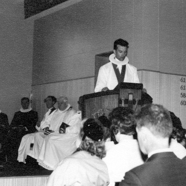 Séra Magnús Guðmundsson predikar í fallegri og nýrri Grundarfjarðarkirkju. ,,Það verður vafalaust sagt að þau hjón, séra Magnús og Áslaug, hafi reist sér minnisvarða með kirkjubyggingunni og þeirri glæsilegu starfsaðstöðu sem nú er til staðar,- miklu er þó dýrmætari sá óbrotgjarni minnisvarði sem þau hafa reist í hugum fólksins, með framgöngu sinn, ástúð sinni og umhyggju í allra garð í gleði og sorgum.’’ Bjarni Sigurðsson sagði þessi fallegu orð um fráfarandi sóknarprest við nýja sóknarprestinn séra Jón Þorsteinsson sem ritaði þau niður í minningargrein.