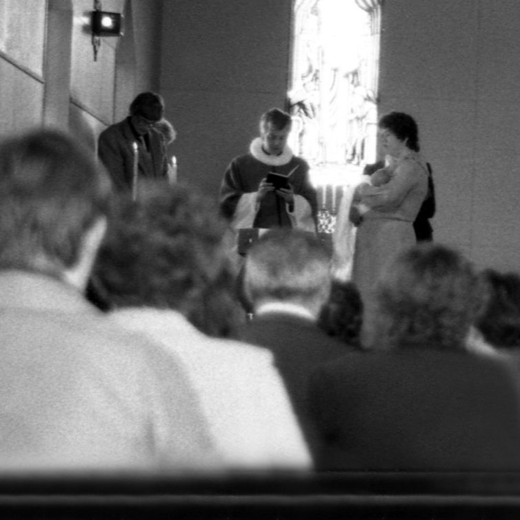 Hér er verið að skýra frumburð þeirra Trissu og Helga hann Sigurð Tómas. Talið frá vinstri Helgi Sigurðsson, sr.Jón Þorsteinsson og Patricia Ann Heggie með Sigurð Tómas Helgason í fanginu