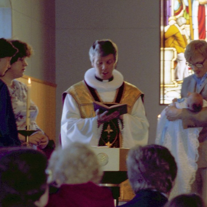 Hér er verið að skýra son þeirra Trissu og Helga hann Adam Kára. Talið frá vinstri Bergþóra Sigurðardóttir, Patricia Ann Heggie, sr. Jón Þorsteinsson og Helgi Sigurðsson með son sinn Adam Kára Sigurðsson í fanginu.