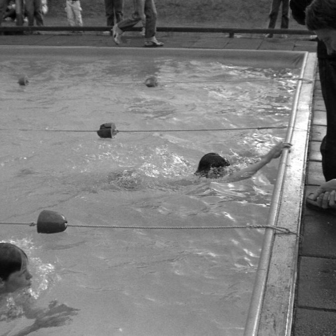 Hér er Sigurberg Árnason að taka tímann hjá sundfólki. ,,Sundlaug er því hið mesta þarfaþing fyrir staði eins og Grundarfjörð og getur verið mikil félagsleg lyftistöng. Við spyrjum Guðráð hvort sund sé nú ekki æft sem keppnisíþrótt. Hann kveður varla orð á því gerandienn sem komið er, en það sé greinilega mjög vaxandiáhugi á sundi meðal yngri bæjarbúaog því muni sundþjálfun og keppni vafalaust aukast mjög á næstunni.’’ (9. Júlí 1977).