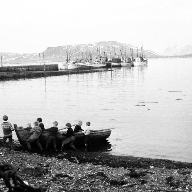 Þessi skemmtilega mynd er af ungum og athafnasömum krökkum, það eru eflaust margir sem kannast við sig og aðra á myndinni og langar okkur að fá bæði nöfn og lýsingu þeirra á hvað þau eru að brasa og hvernig fór um sjóferð þá. Eins væri gaman að fá nöfn bátanna á myndinni.