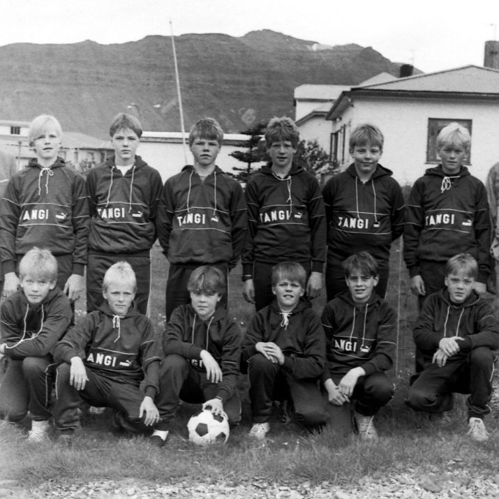 Á þessari mynd eru í aftari röð: Hjálmar Gunnarsson útgerðarmaður Tanga að færa UMFG fótboltaliðinu æfingagalla. Á myndinni eru Hjálmar Gunnarsson, Bjarni Ström, Benedikt Ívarsson, Þröstur Sigmundsson, Hjörtur Guðmundsson, Sverrir Pálmarsson, Steinar Þór Alfreðsson og Gísli Björnsson þjálfari. Í fremri röð eru: Friðfinnur Níelsson, Atli Már Ingólfsson, Ragnar Börkur Ragnarsson, Guðmundur Ólason, Gísli Svanur Gíslason og Marvin Ívarsson.