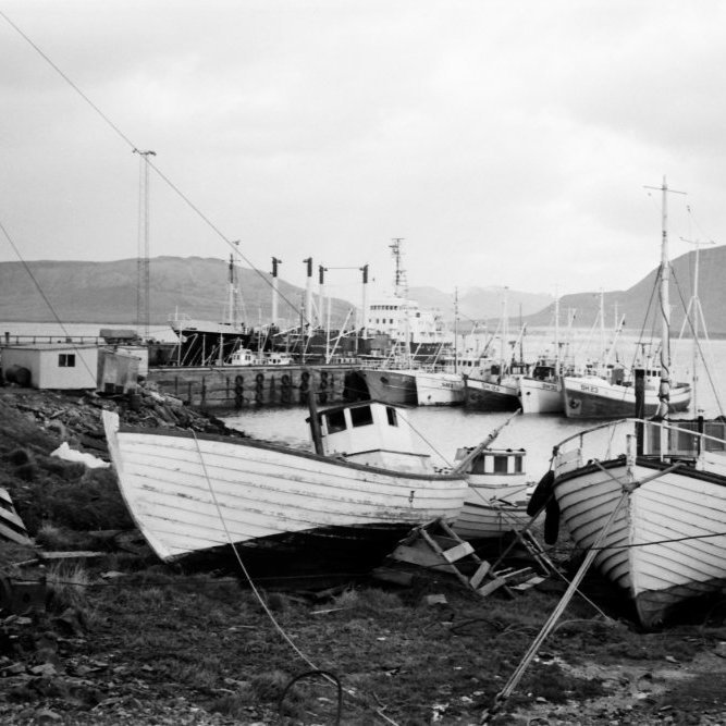Logn og blíða við Grundarfjarðarhöfn. Þarna sjást beitningaskúrarnir og Neshúsin. Í fjörunni fyrir neðan Kaupfélagið átti hver smábátur og trilla sitt pláss. Þarna var eitt af skemmtilegri leiksvæðum þorpsins.