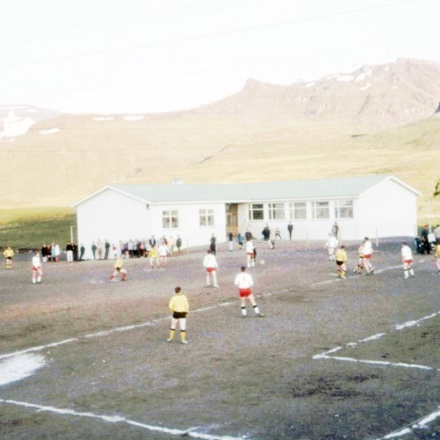 Fótboltaleikur við Grunnskóla Eyrarsveitar. Þarna eru að keppa UMFG, Grundfirðingar (gulir og svartir) á móti Snæfelli, Hólmarar (hvítir og rauðir). Völlurinn er þarna merktur með salti, allar línur voru markaðar með salti á þessum árum.