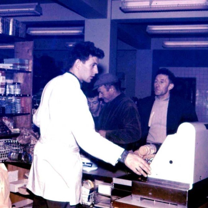 Mynd tekin í Kaupfélagi Grundfirðinga. Afgreiðslumaðurinn er Adólf Haraldsson.  Talið frá hægri þeir sem eru að versla eru Jóhann Ásmundsson frá Kverná, Elberg Guðmundsson og Friðfinnur Friðfinnsson.