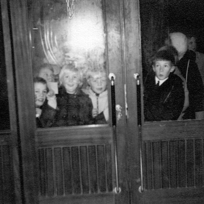 Sparibúin börn og foreldrar fyrir utan 