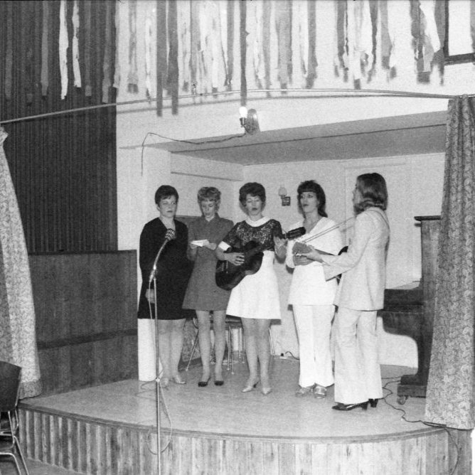 Skemmtun/árshátíð kvenfélagsins í samkomuhúsinu sennilega árið 1973, en þá fóru skemmtiatriðin fram á litlu senunni því setið var til borðs á stóri senunni. Hér skemmta þær talið frá hægri Auðbjörg Árnadóttir, Svava Axelsdóttir, Kristín Friðfinnsdóttir, Jóhanna Sigurrós Árnadóttir og Jensína Guðmundsdóttir.