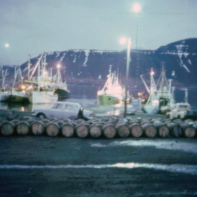 Þarna eru síldartunnum raðað upp við Hafnarskúrinn og er spurning hvort þær eru frá síldarvinnslunni sem var í gangi hjá Soffaníasi, það væri gaman að fá að vita meira um hvað var að gerast á þessari skemmtilegu mynd