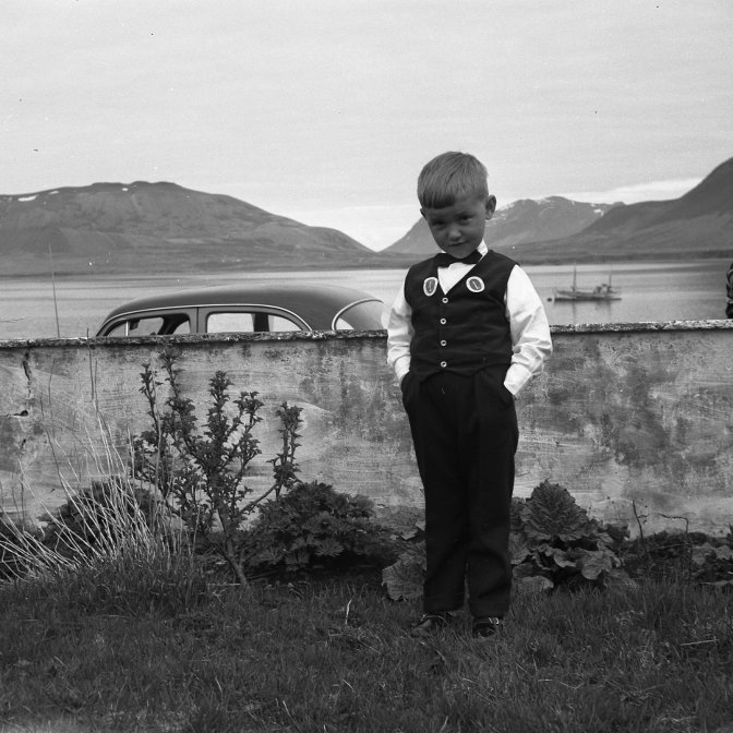 Þessa mynd tók Bæring nokkru fyrir árið 1960 úr garði fjölskyldunnar frá Búðum að Grundargötu 17. Ekki er farið að byggja þarna húsin númer 18 og 20 á Grundargötu, sjávarmegin. Hverjir eru drengirnir á myndinni og hvaða bíll skildi vera hinumegin við vegginn og hvaða bátur liggur við ból á firðinum? grundarfjordur@grundarfjordur.is