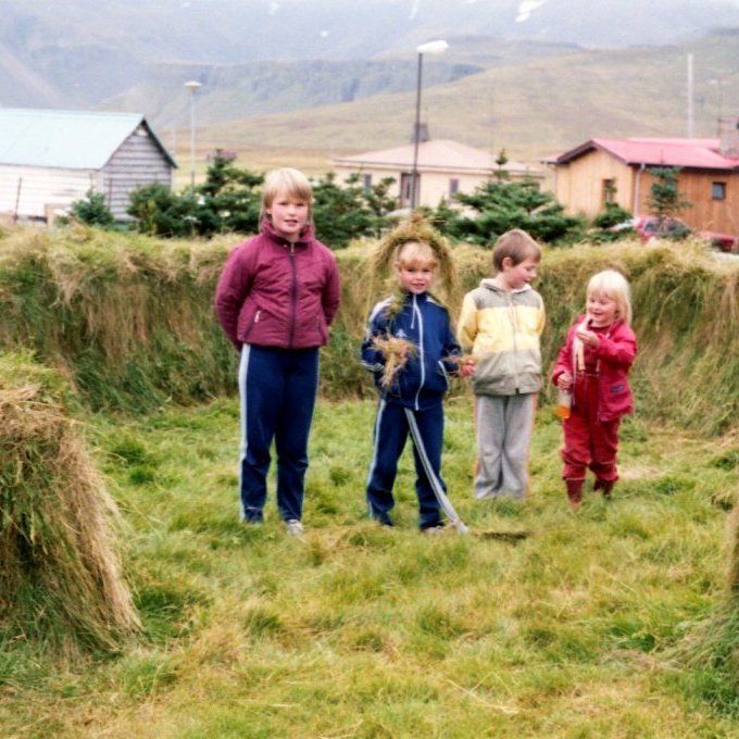 Mynd tekin í garðinum hjá Huldu og Soffa á Hlíðarvegi. Litlu stúlkurnar sem eru að leika sér í heyinu eru talið frá vinstri, Elísabet Lára Sveinsdóttir, Elísabet Svava Kristjánsdóttir, Helga Pétursdóttir og Sylvía Rós Ríkarðsdóttir.