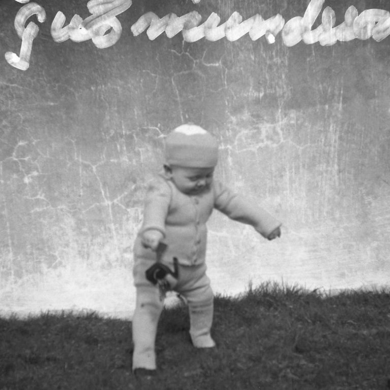 Hér er ungur drengur að stíga fyrstu skrefin fyrir utan heimili sitt Götuhús sem stóð við Grundargötu 12. Barnið er Runólfur Guðmundsson sem átti afmæli núna 12 maí, Runni hefur búið allan sinn aldur í Grundarfirði og ýmislegt brallað og byggt upp á staðnum.