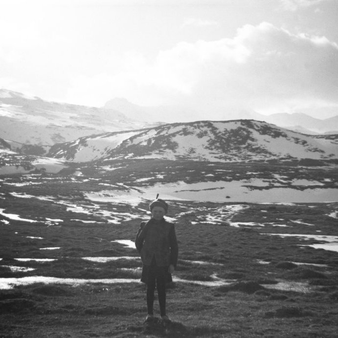 Á þessari mynd sjást vel þær breytingar sem orðið hafa á nokkrum áratugum. Hellnafellin blasa við og þar fyrir ofan Helgrindur, fyrir aftan drenginn er Ölkeldudalur og hæðin þar fyrir aftan Tumastekkur og þar fyrir aftan er Tumastekkur. Líklega stendur drengurinn þar sem núna er Borgarbraut 18? Gaman væri að fá nafnið á honum ef einhver þekkir til og hvað er hann með á bakinu?