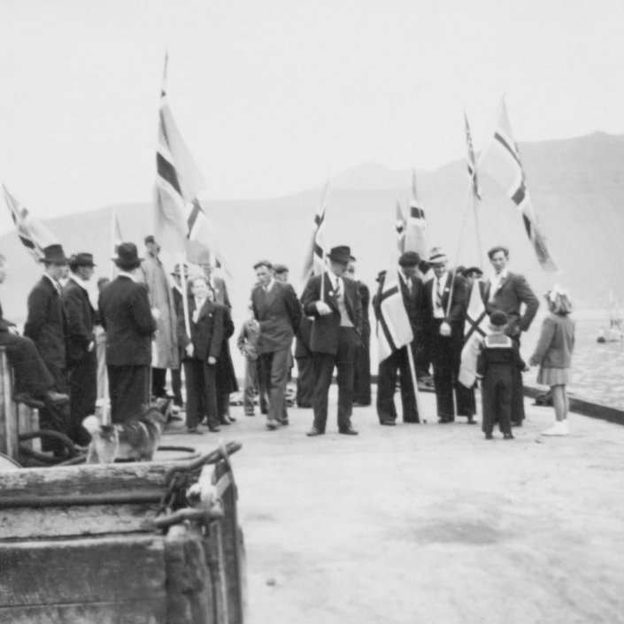 Sjómannadagur haldinn hátíðlegur í þorpinu unga, Grafarnesi, líklega á sjötta áratugnum. Þarna eru sjómenn og fjölskyldur að gera sig klár í skrúðgöngu frá bryggjunni. Sjómannadagurinn er fyrsti sunnudagurinn í júní ár hvert, nema ef hvítasunnu ber upp á þann dag, þá er hann næsti sunnudagur þar á eftir. Sjómannadagurinn er hátíðisdagur allra sjómanna. Dagurinn var fyrst haldinn hátíðlegur þann 6. júní árið 1938 í Reykjavík og á Ísafirði. Frá upphafi 20. aldar tíðkaðist að halda sérstakar sjómannamessur í kirkjum áður en þilskipin héldu til veiða eftir vetrarlægi, sem var yfirleitt 3. eða 4. sunnudag eftir þrettánda. Árið 1987 var dagurinn lögskipaður frídagur sjómanna.